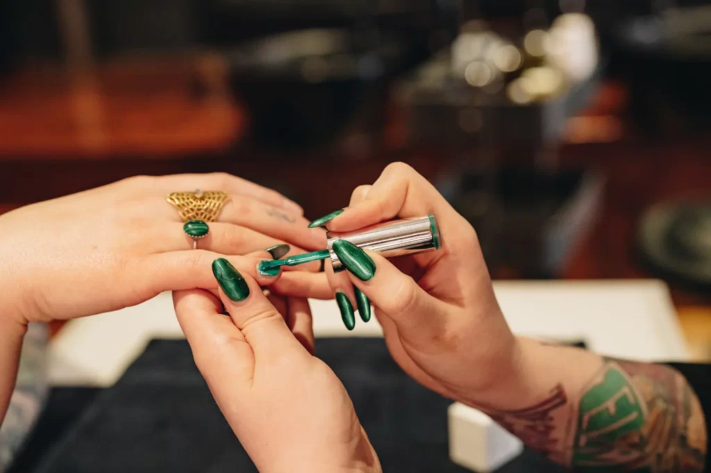 Green, non-toxic nail polish being applied to client